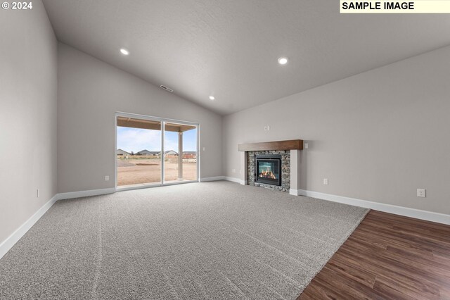 unfurnished living room featuring a fireplace, vaulted ceiling, and hardwood / wood-style flooring