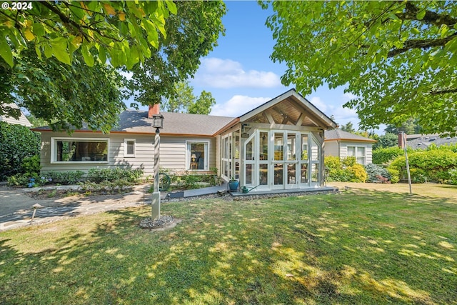 back of property featuring a lawn and a sunroom