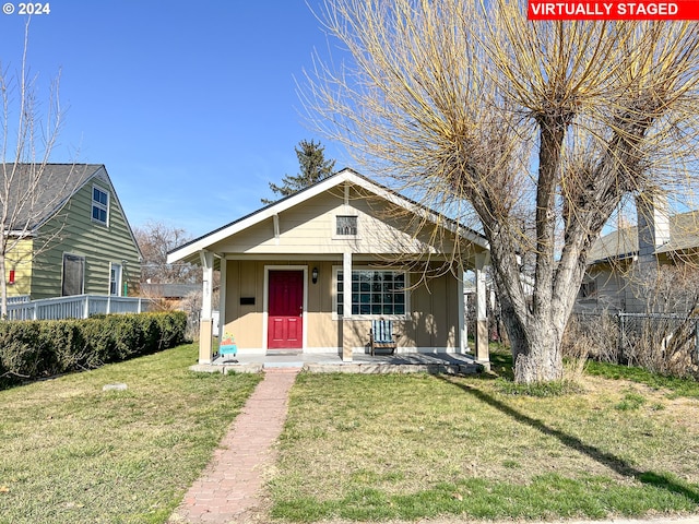 bungalow-style house featuring a front yard and covered porch