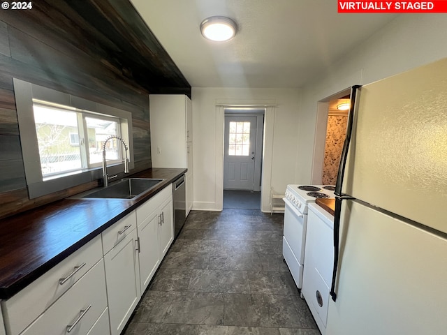 kitchen with white appliances, white cabinets, dark tile floors, and sink