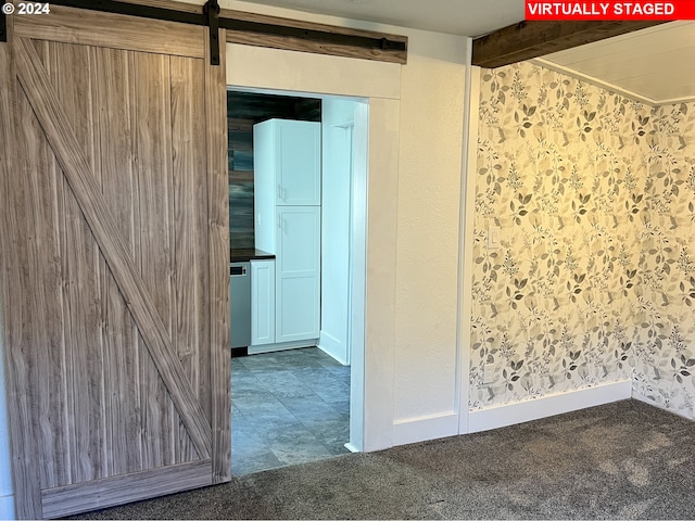 unfurnished room featuring carpet floors and a barn door