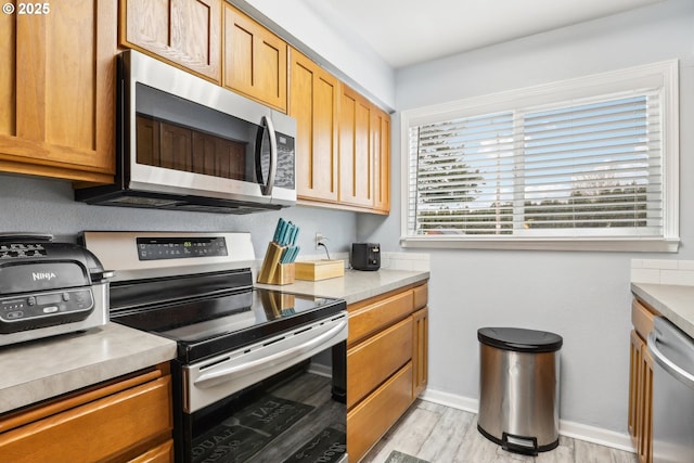 kitchen featuring light wood-type flooring and appliances with stainless steel finishes