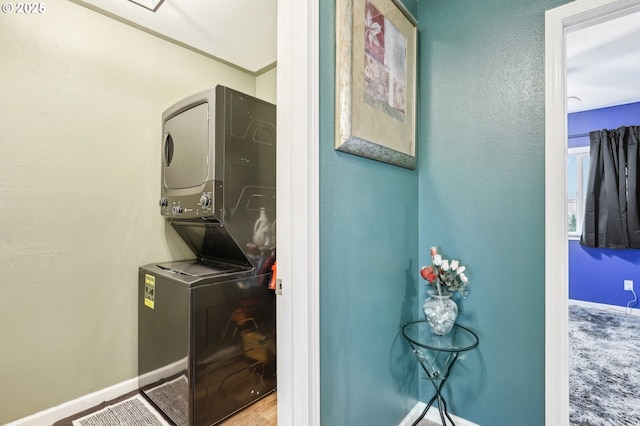 laundry area featuring stacked washer and dryer and carpet floors