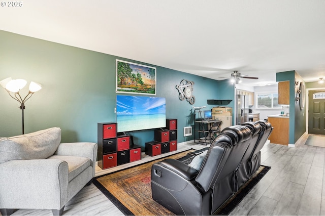 living room with light hardwood / wood-style floors and ceiling fan