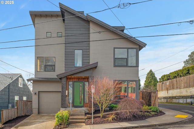 view of front of house featuring a garage, driveway, fence, and brick siding