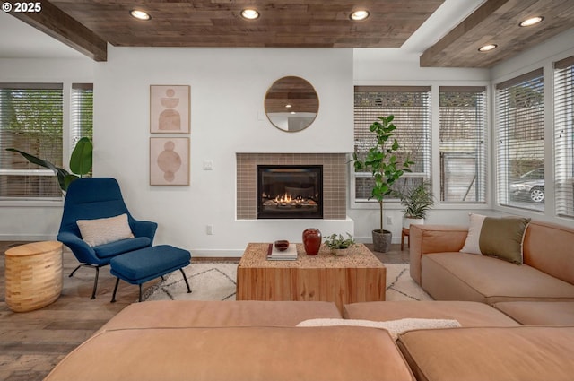 living area featuring light wood finished floors, a tile fireplace, and recessed lighting