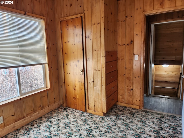 unfurnished room featuring wooden walls and wood-type flooring