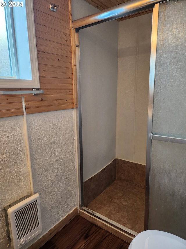 bathroom featuring walk in shower, toilet, and hardwood / wood-style flooring