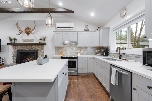 kitchen with stainless steel appliances, sink, lofted ceiling with beams, an AC wall unit, and a fireplace