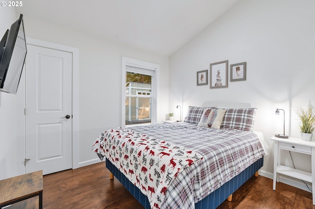 bedroom with dark wood-type flooring and vaulted ceiling