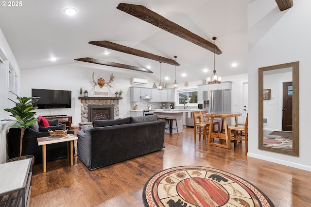 living room featuring a wall mounted AC, sink, lofted ceiling with beams, hardwood / wood-style floors, and a stone fireplace