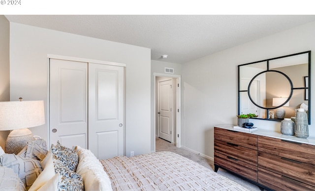 bedroom featuring light colored carpet and a closet