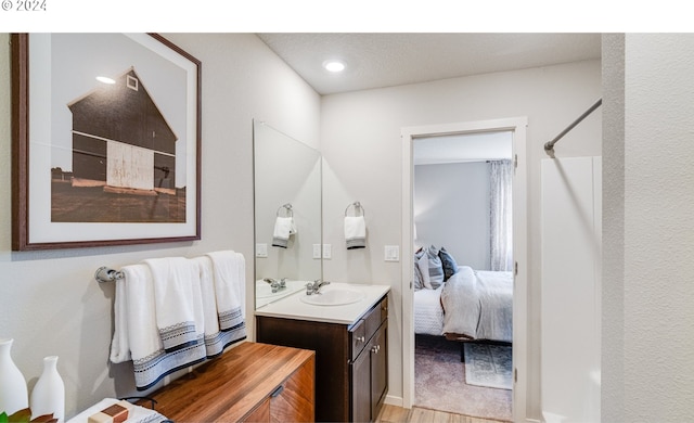 bathroom featuring vanity, walk in shower, and hardwood / wood-style floors