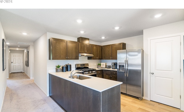 kitchen with kitchen peninsula, dark brown cabinets, light hardwood / wood-style flooring, sink, and stainless steel appliances