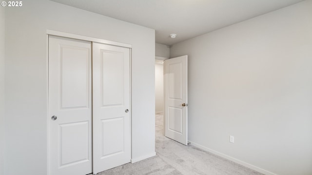 unfurnished bedroom featuring a closet and light carpet