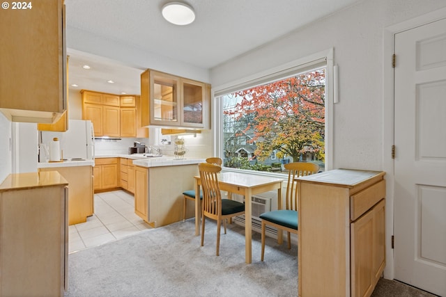 kitchen with tile counters, sink, a textured ceiling, light carpet, and light brown cabinetry