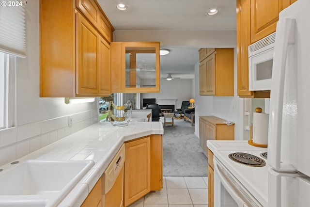 kitchen with tile countertops, white appliances, and light colored carpet