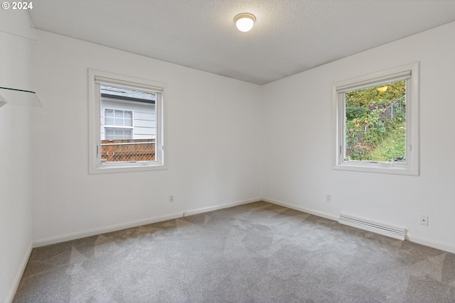 unfurnished room with carpet, a textured ceiling, and baseboard heating