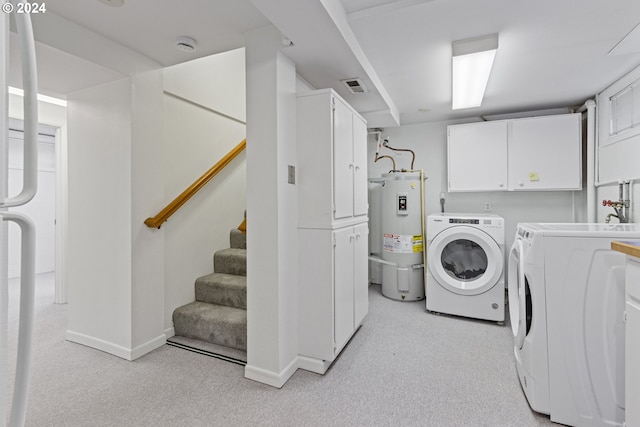 washroom with secured water heater, separate washer and dryer, light carpet, and cabinets