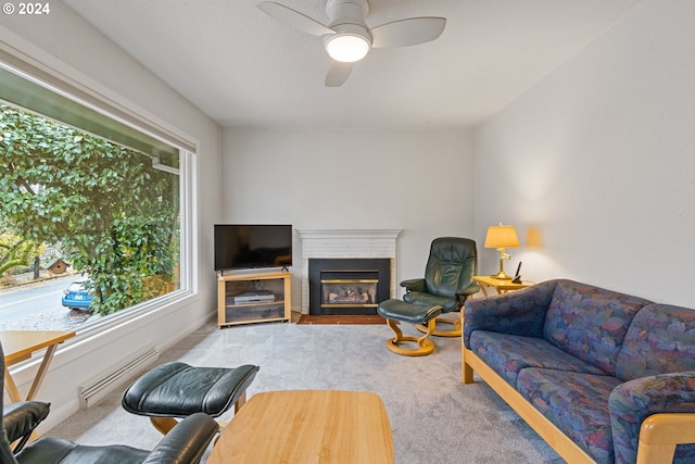 carpeted living room with ceiling fan and a baseboard heating unit