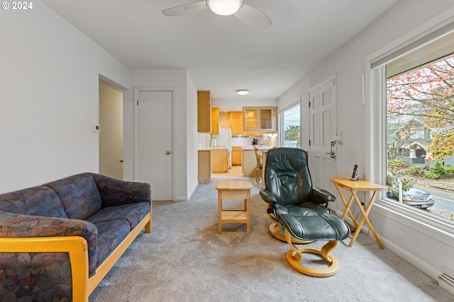 carpeted living room with ceiling fan and baseboard heating