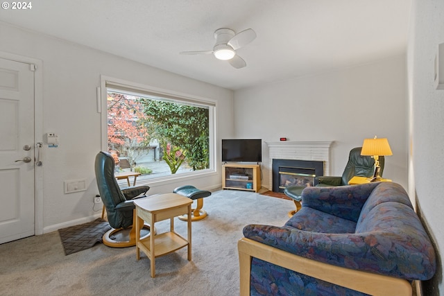 living room with carpet, a brick fireplace, and ceiling fan