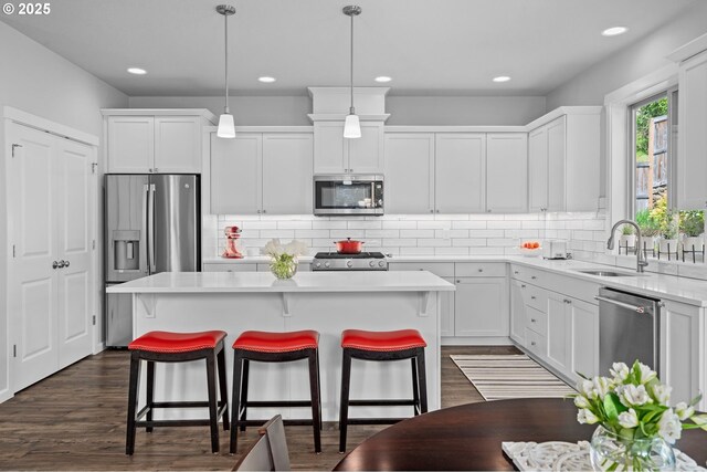 1010 NW 1st St, Dundee, OR 97115 - kitchen featuring white cabinets, stainless steel appliances, light countertops, a sink, and a kitchen island
