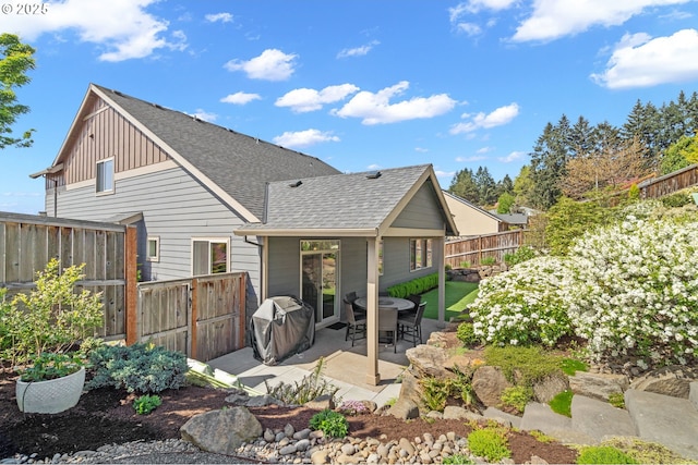1010 NW 1st St, Dundee, OR 97115 - back of property with a fenced backyard, roof with shingles, a patio, and board and batten siding