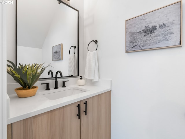 bathroom with vanity and lofted ceiling