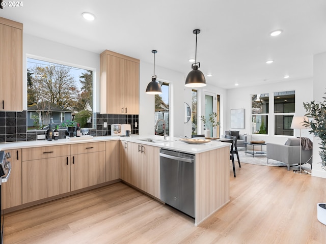 kitchen featuring hanging light fixtures, a healthy amount of sunlight, light brown cabinetry, and stainless steel appliances