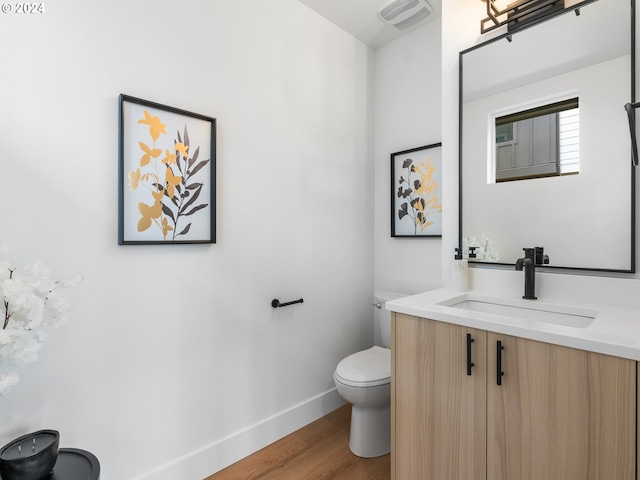 bathroom with vanity, hardwood / wood-style flooring, and toilet