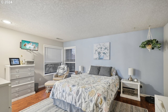 bedroom with a textured ceiling and hardwood / wood-style flooring