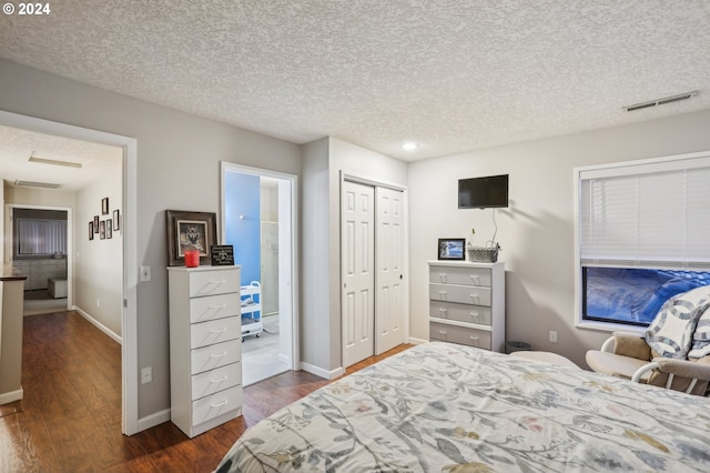 bedroom with a closet, dark hardwood / wood-style flooring, and a textured ceiling