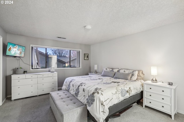 bedroom featuring light colored carpet and a textured ceiling