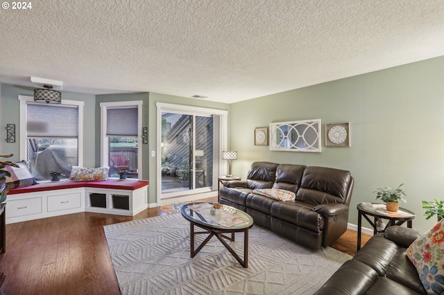 living room featuring light wood-type flooring and a textured ceiling