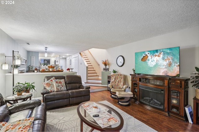 living room with wood-type flooring and a textured ceiling