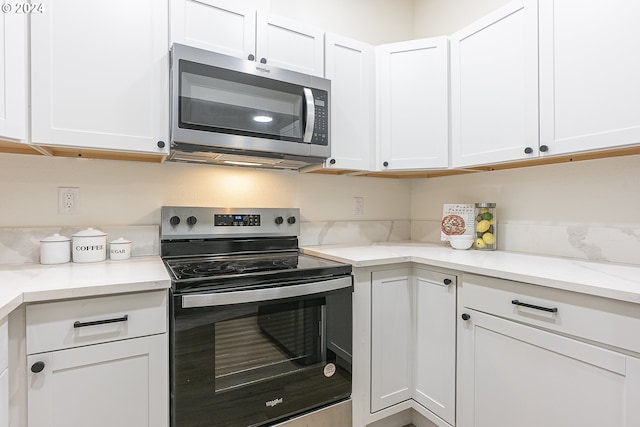 kitchen with light stone counters, white cabinets, and appliances with stainless steel finishes