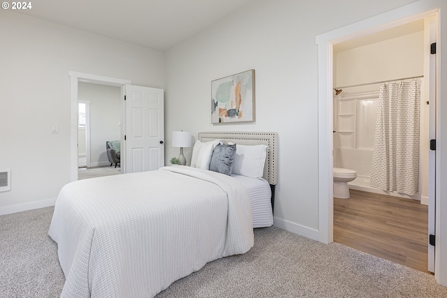 bedroom with wood-type flooring and connected bathroom