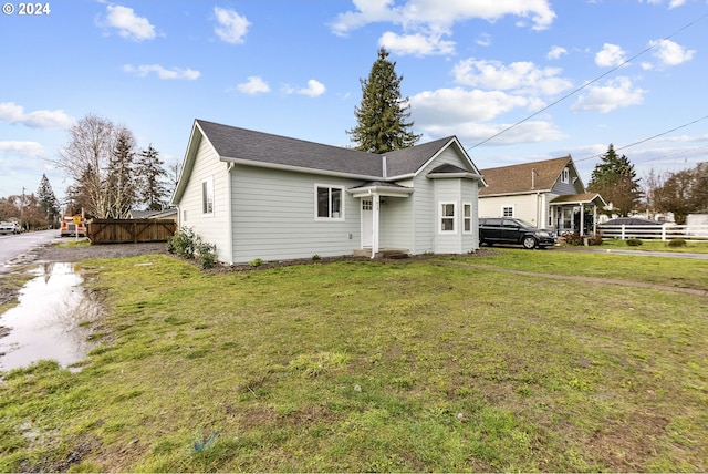 rear view of house featuring a lawn