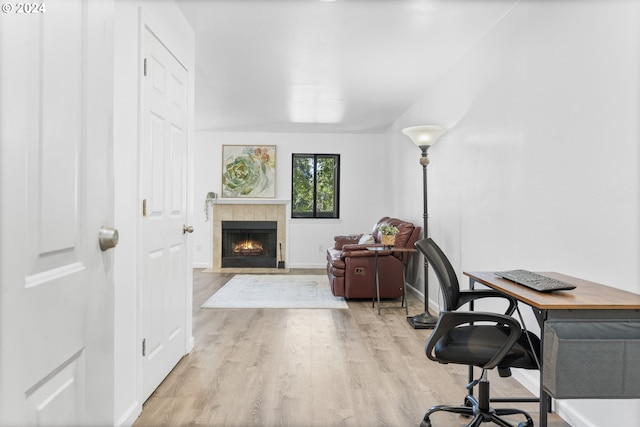 office space with a fireplace and light wood-type flooring