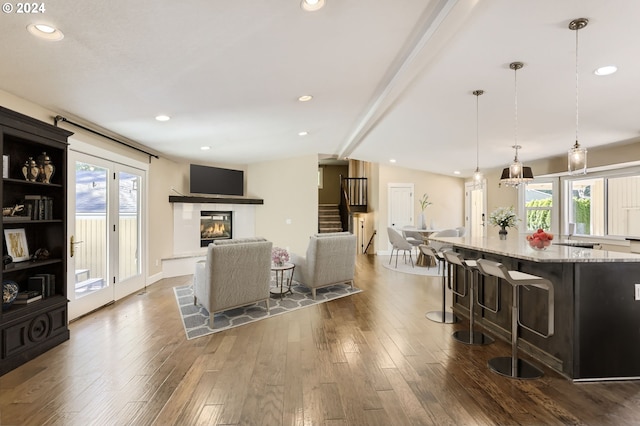 living room featuring lofted ceiling with beams, a wealth of natural light, and dark wood-type flooring