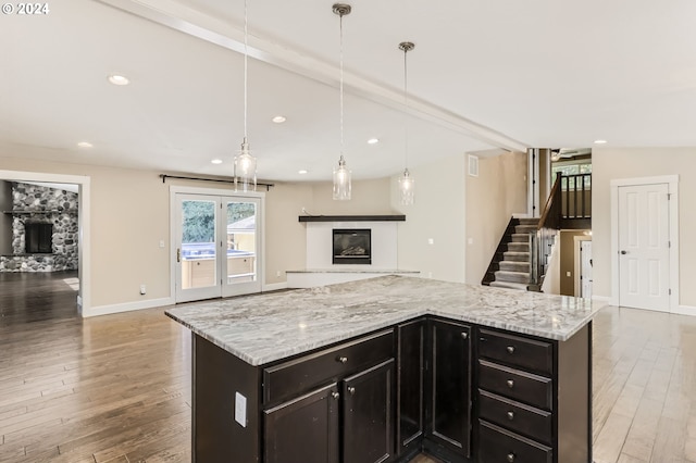 kitchen featuring decorative light fixtures, light hardwood / wood-style flooring, and a kitchen island