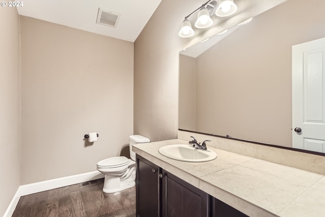 bathroom with hardwood / wood-style floors, vanity, and toilet