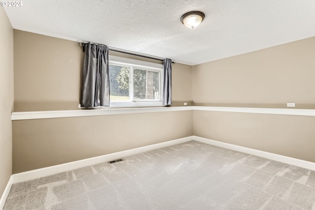 empty room featuring carpet floors and a textured ceiling