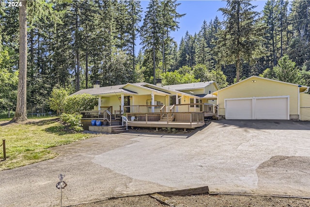 view of front of property with a porch, a front yard, an outdoor structure, and a garage