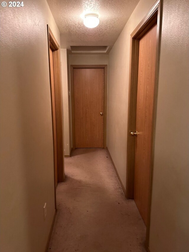 hall featuring a textured ceiling
