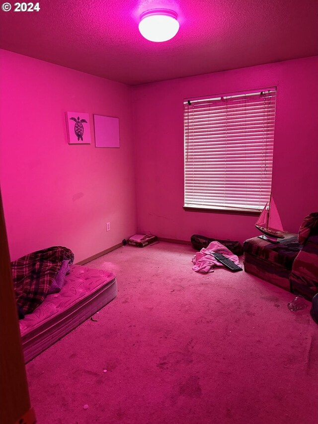 carpeted bedroom featuring a textured ceiling and baseboards