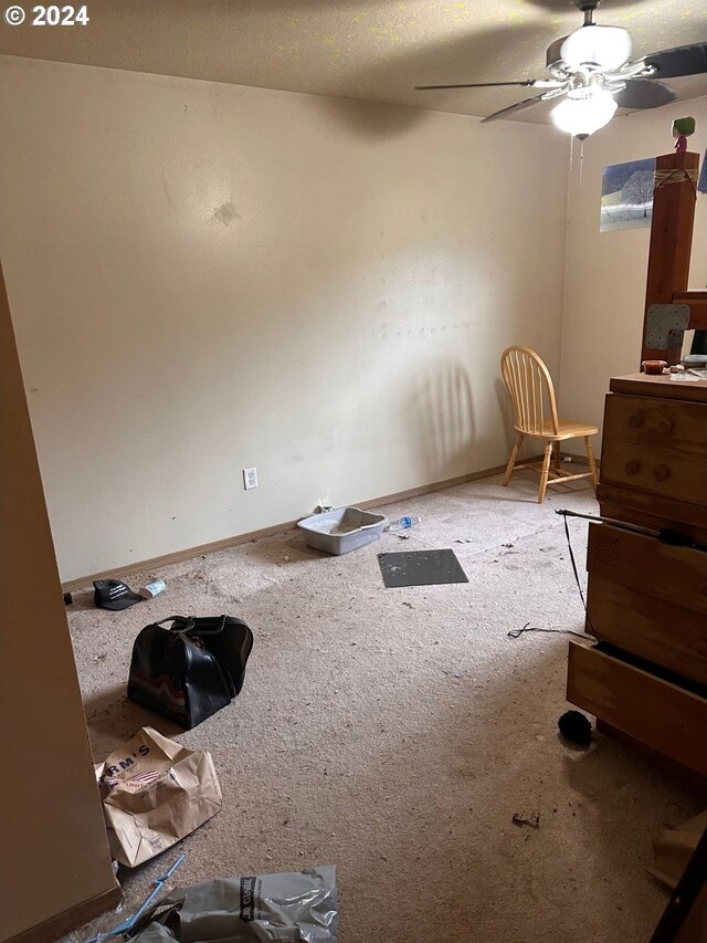 unfurnished dining area with baseboards, ceiling fan, and carpet