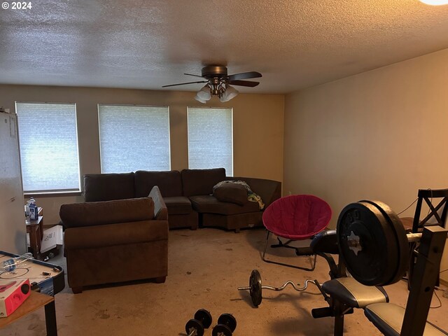 living room featuring a ceiling fan and a textured ceiling