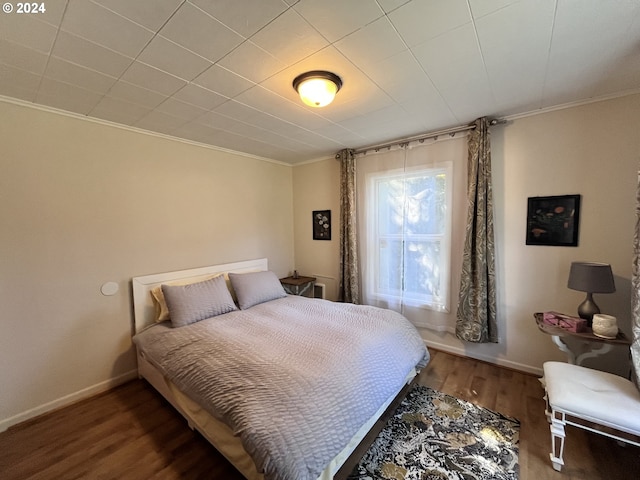 bedroom featuring crown molding and wood-type flooring